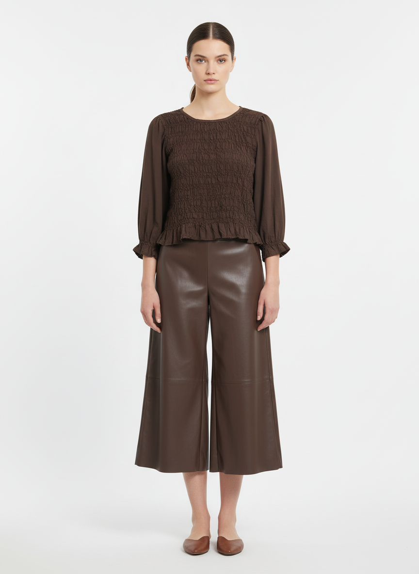 Modelo con conjunto marrón de blusa fruncida y pantalones culotte